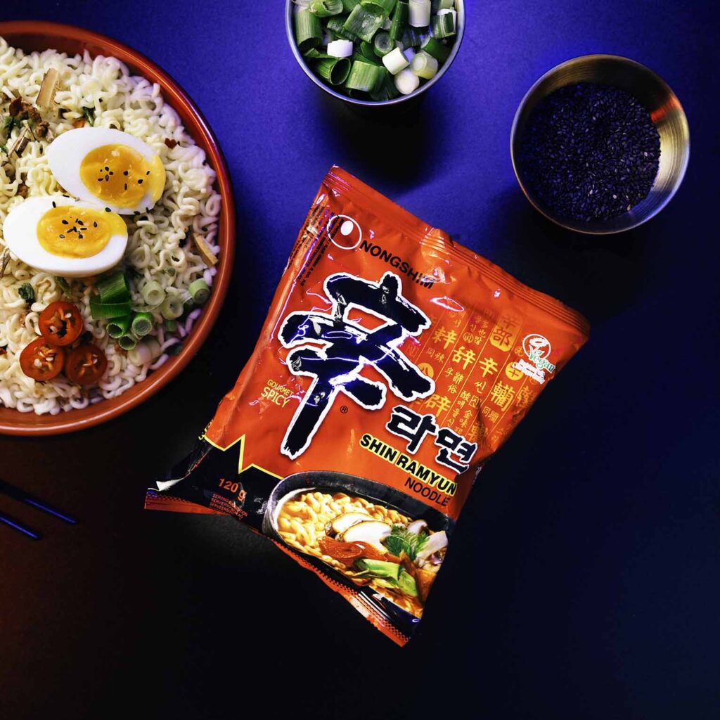 Nongshim Shin Ramyun Noodle Packung neben serviertem Essen